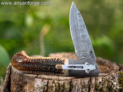 Stainless steel pocket clip on Damascus folding knife, ideal for secure everyday carry.
