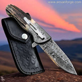 Ansari Forge Damascus pocket knife open, showcasing raindrop pattern blade and Sambar stag antler handle.