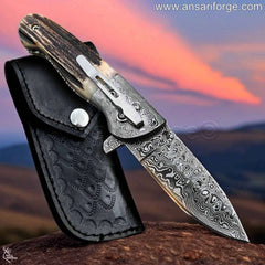 Ansari Forge Damascus pocket knife open, showcasing raindrop pattern blade and Sambar stag antler handle.