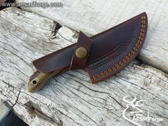 Ansari Forge Damascus Knife securely housed in a hand-stitched genuine cowhide leather sheath, ready for outdoor use.