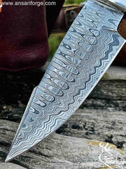 Close-up of a Damascus Hunting Bowie Knife with a ladder pattern.