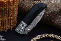 Closed Damascus pocket knife with brass frame and micarta handle.