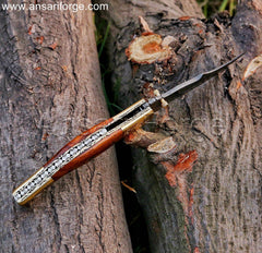Damascus Folding Knife with a twist pattern blade, walnut wood handle, file work on spine and engraved brass bolsters, displayed open.