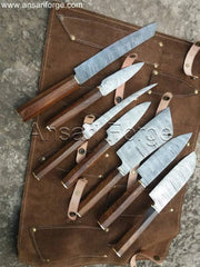 Hand-forged Damascus steel chef knife set with octagonal rosewood handles, displayed in a leather roll-up bag.
