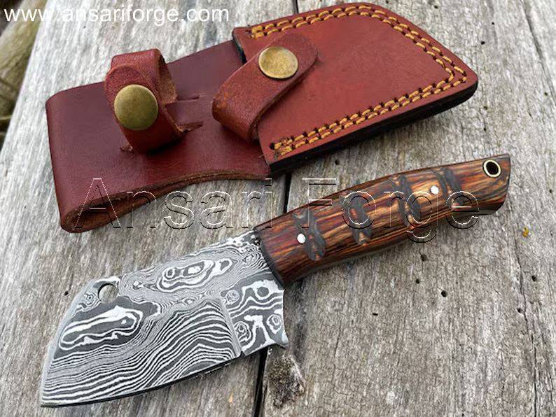Damascus Bushcraft Knife with raindrop pattern, fixed blade, Pakkawood handle, and leather sheath.