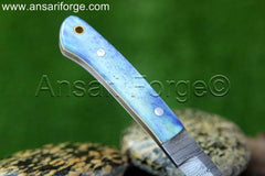 A close-up of a Custom Damascus Bird And Trout Knife, showcasing the intricate details of the Damascus steel and the beautiful camel bone handle.