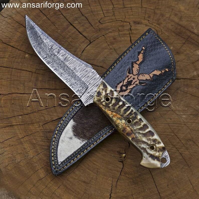 Markhor Hunter Damascus Steel Knife with fire-patterned blade, sheep horn handle, and leather sheath with scrimshaw art.