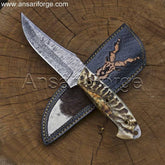 Markhor Hunter Damascus Steel Knife with fire-patterned blade, sheep horn handle, and leather sheath with scrimshaw art.