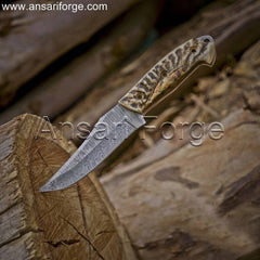 Markhor Hunter Damascus Steel Knife with camping gear, ideal for outdoor adventures.