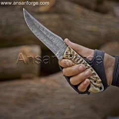 Person holding Markhor Hunter Damascus Steel Knife outdoors, showcasing its comfortable grip.