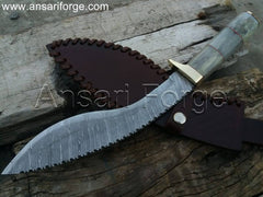 Close-up view of a beautiful Damascus kukri knife with a camel bone handle, leather sheath, and distinct layered blade pattern.