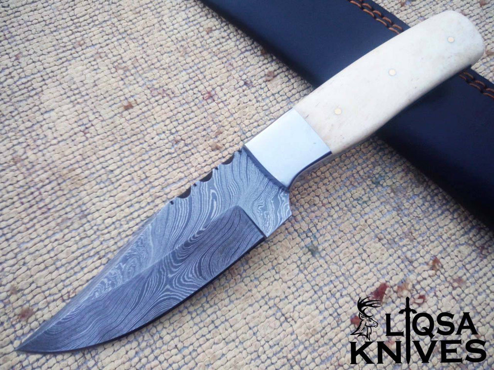 Damascus steel hunting knife bone handle and leather sheath.