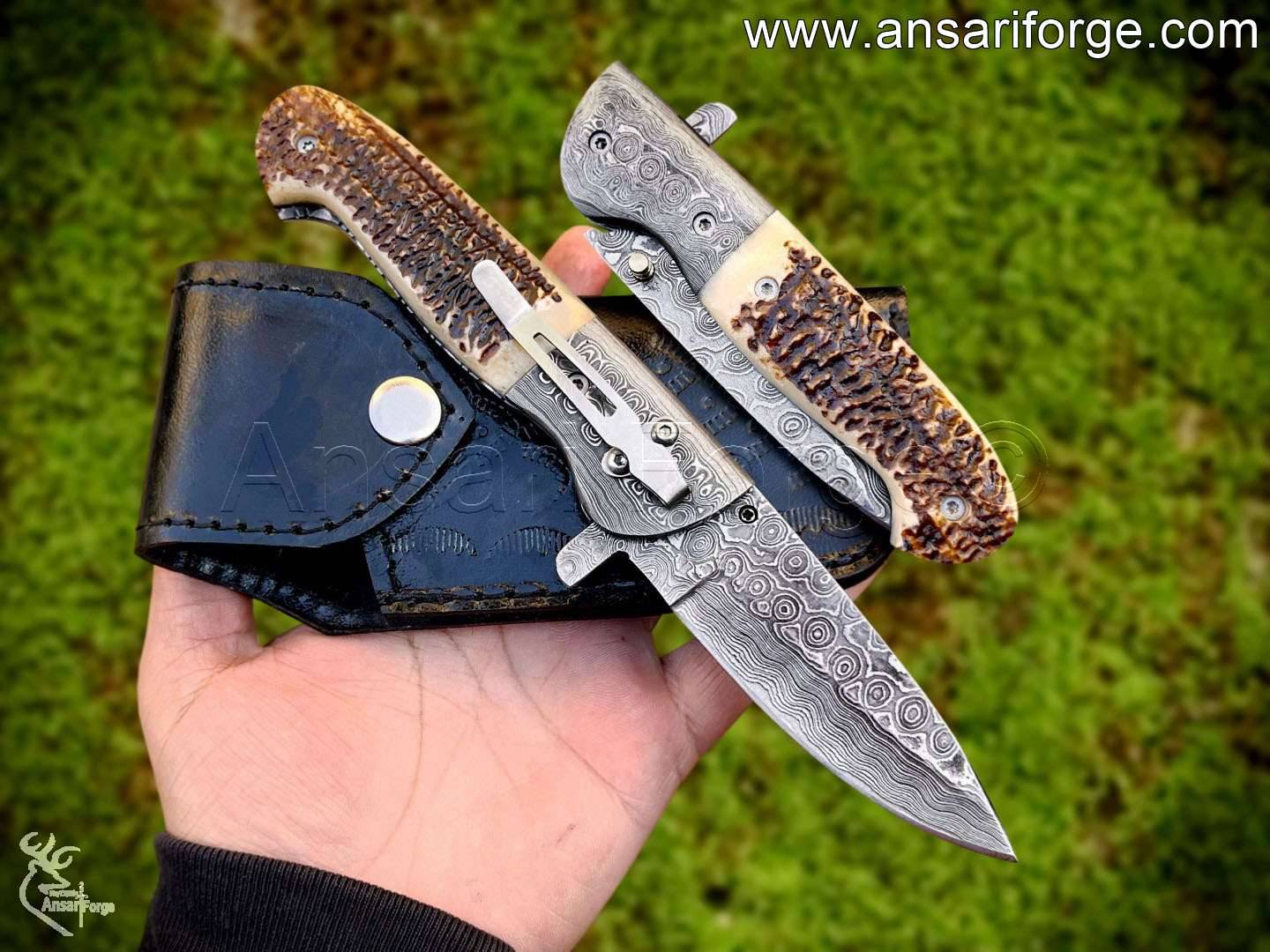 Ergonomic antler handle with Damascus steel bolsters on a premium folding pocket knife.