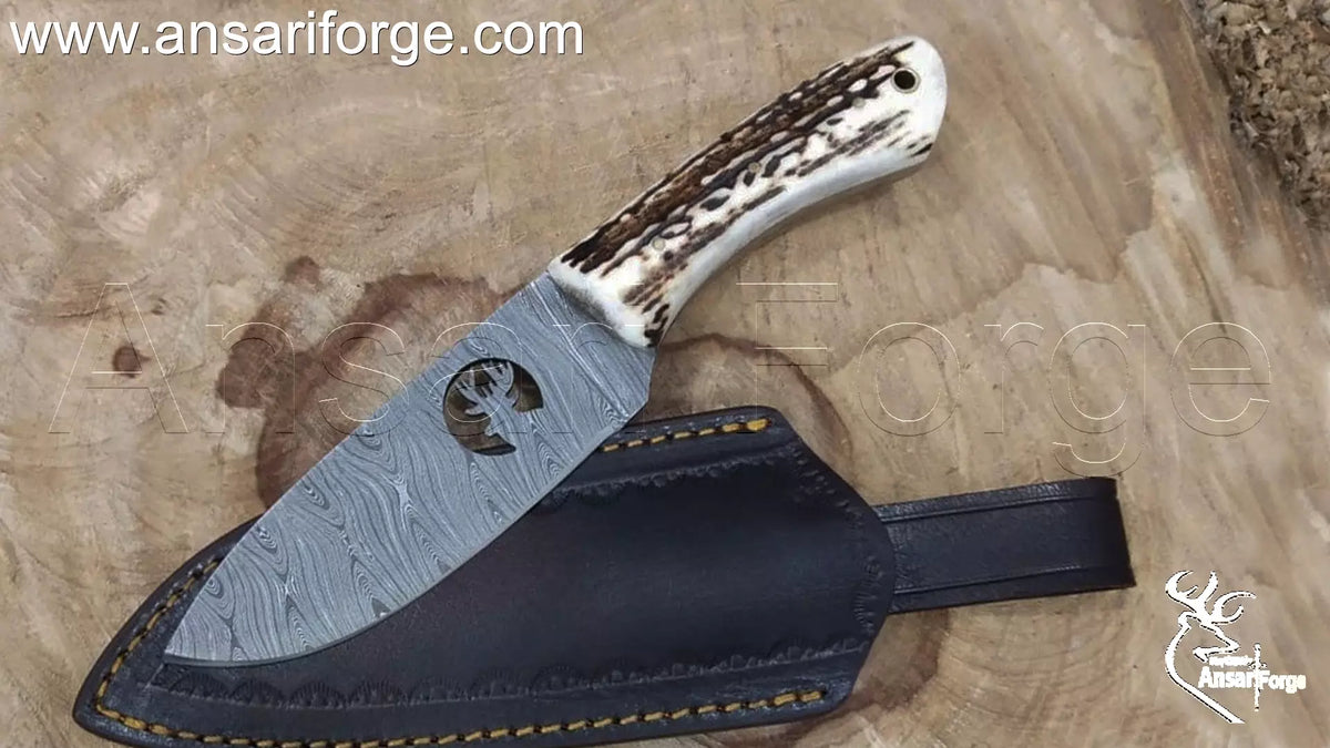 Demascus knife with deer antler handle and handmade cowhide sheath on a wood background.