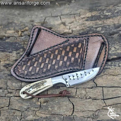 Cowboy knife and sheath with stag antler handle and leather pancake sheath.