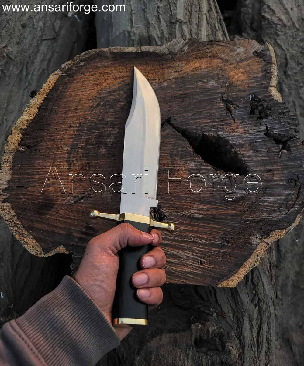 Hand-forged Smithsonian Bowie Knife with 5160 steel clip point blade, brass guard, buffalo horn handle, and leather sheath. Overall length 16 inches.