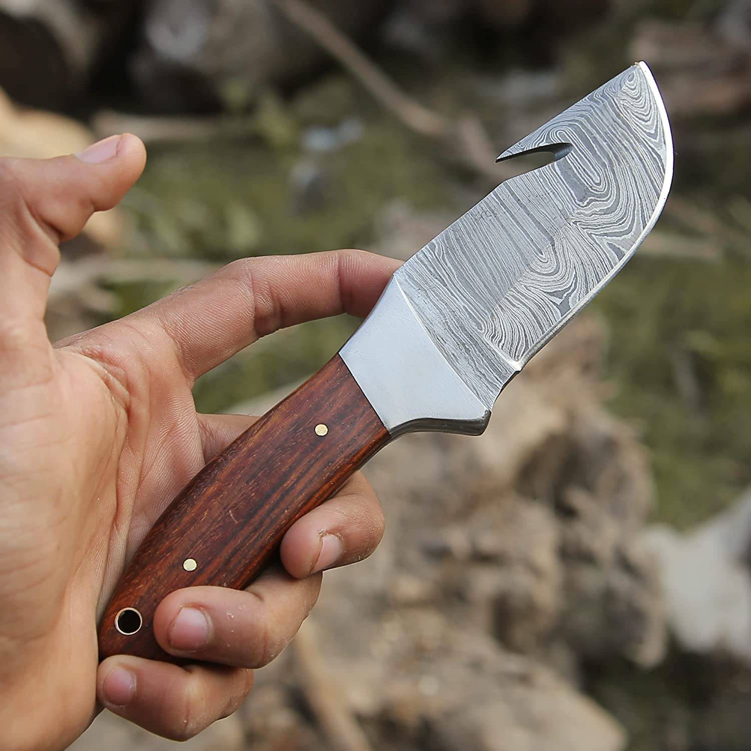 Hunting knife with gut hook being used in the field, demonstrating its practicality for outdoor tasks and hunting.