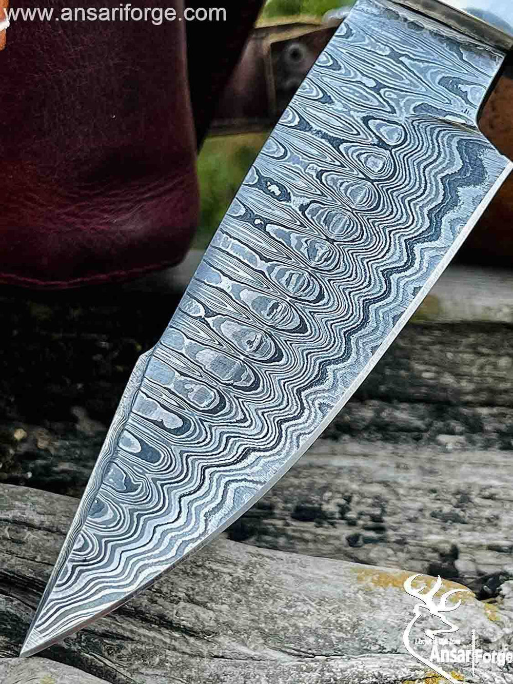 Close-up of a Damascus Hunting Bowie Knife with a ladder pattern.