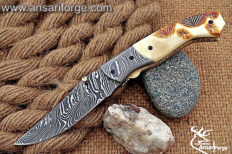 Damascus Pocket Knife by Ansari Forge, featuring a hand-forged Damascus steel blade, camel bone handle, and a liner lock mechanism.