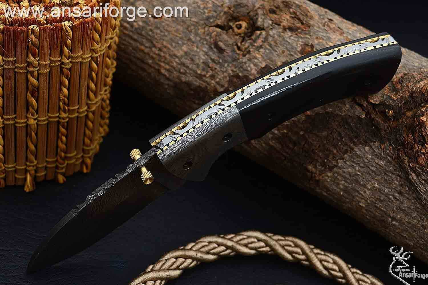 Damascus steel bolsters and file work on brass spine of folding knife.