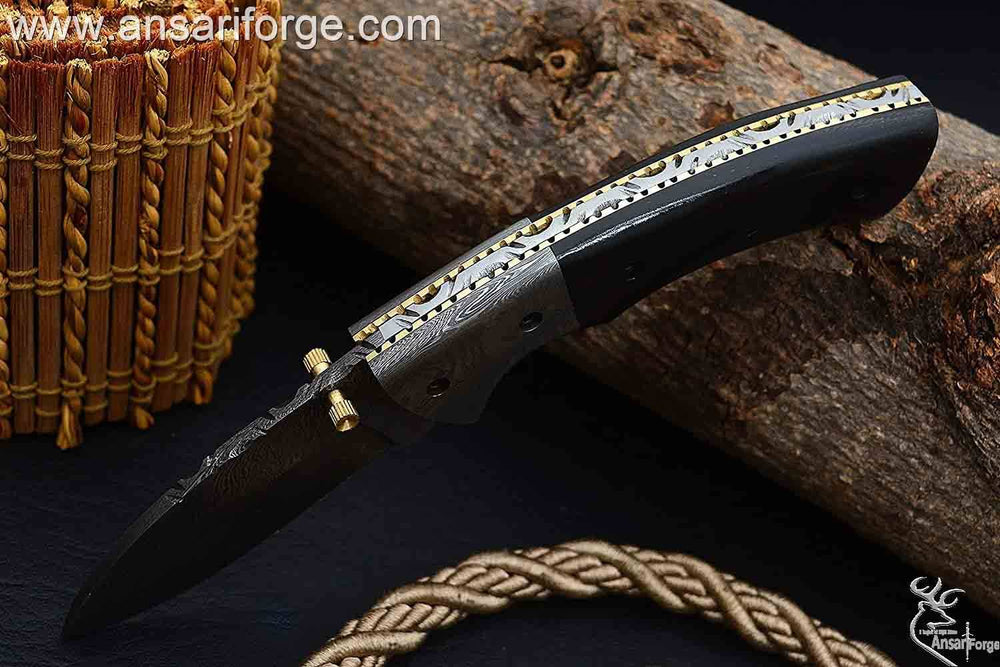 Damascus steel bolsters and file work on brass spine of folding knife.