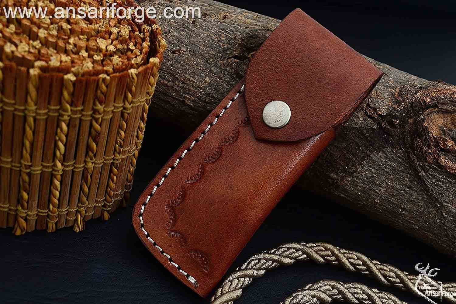 Damascus folding knife in hand leather sheath.