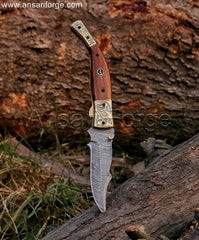 Damascus Folding Knife with a twist pattern blade, walnut wood handle, and engraved brass bolsters, displayed open.