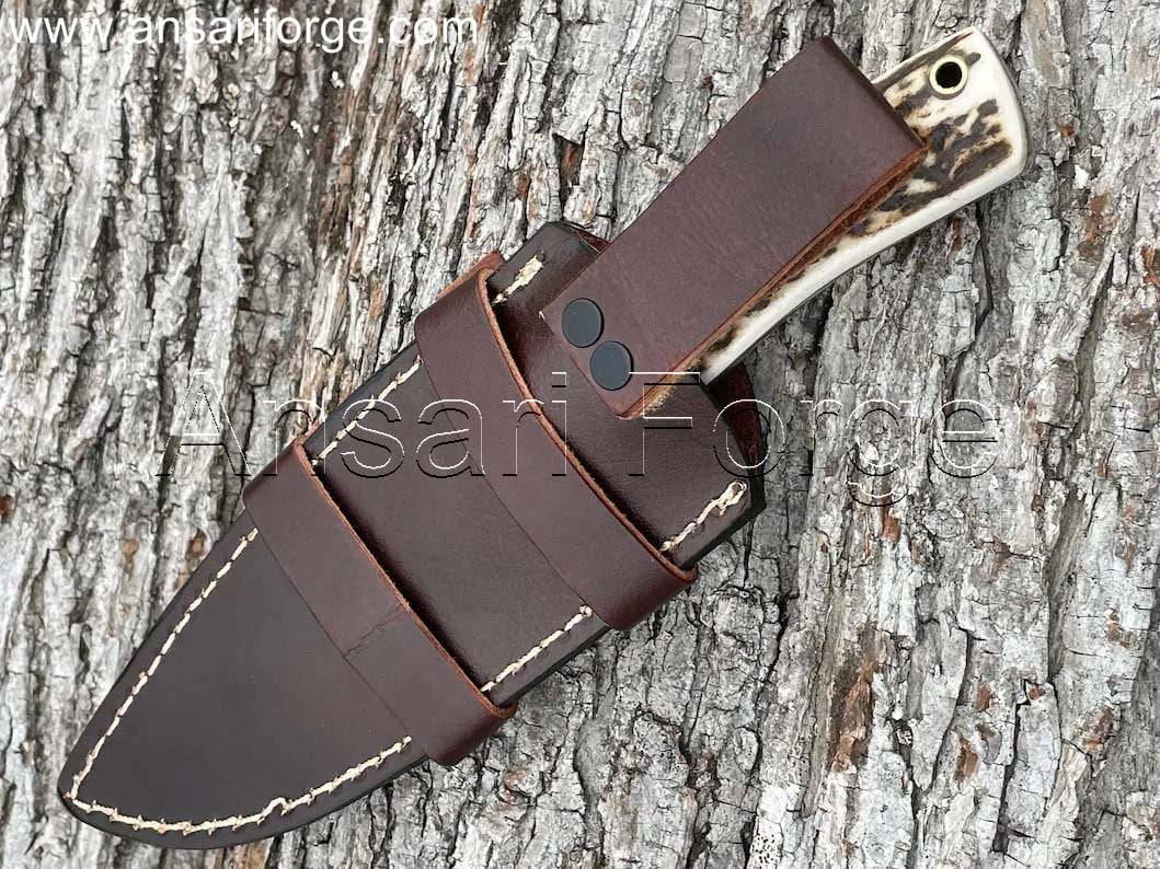 Hand-forged 1095 high carbon steel knife with stag antler handle and cowhide leather scout carry sheath.