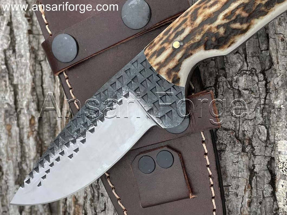 Hand-forged 1095 high carbon steel knife with stag antler handle and cowhide leather scout carry sheath.