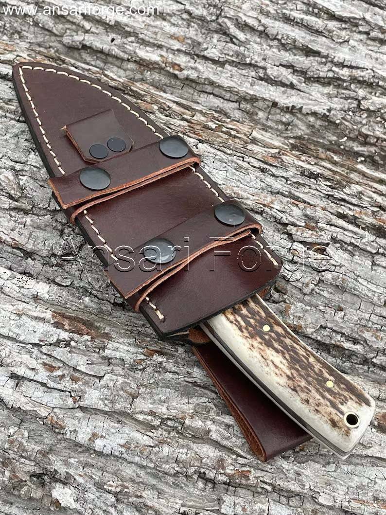Hand-forged 1095 high carbon steel knife with stag antler handle and cowhide leather scout carry sheath.