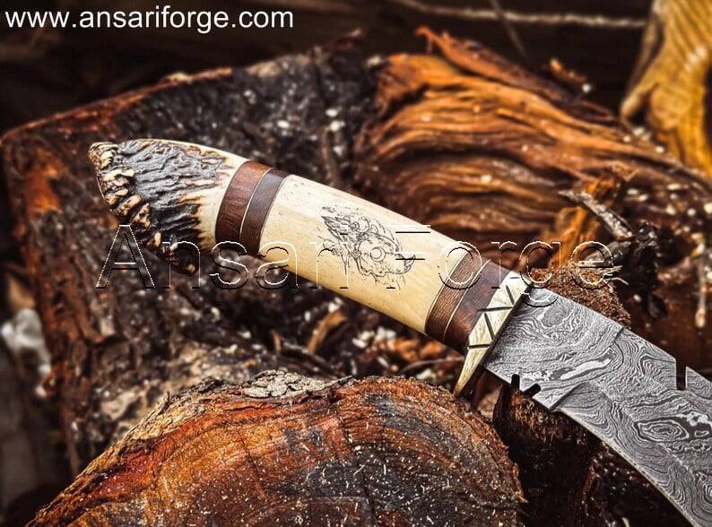 Best kukri knife with Damascus steel blade (1095 & 15N20) showcasing a twist pattern. Brass guard, camel bone and stag antler handle with intricate scrimshaw artwork. Includes a genuine cowhide leather sheath.