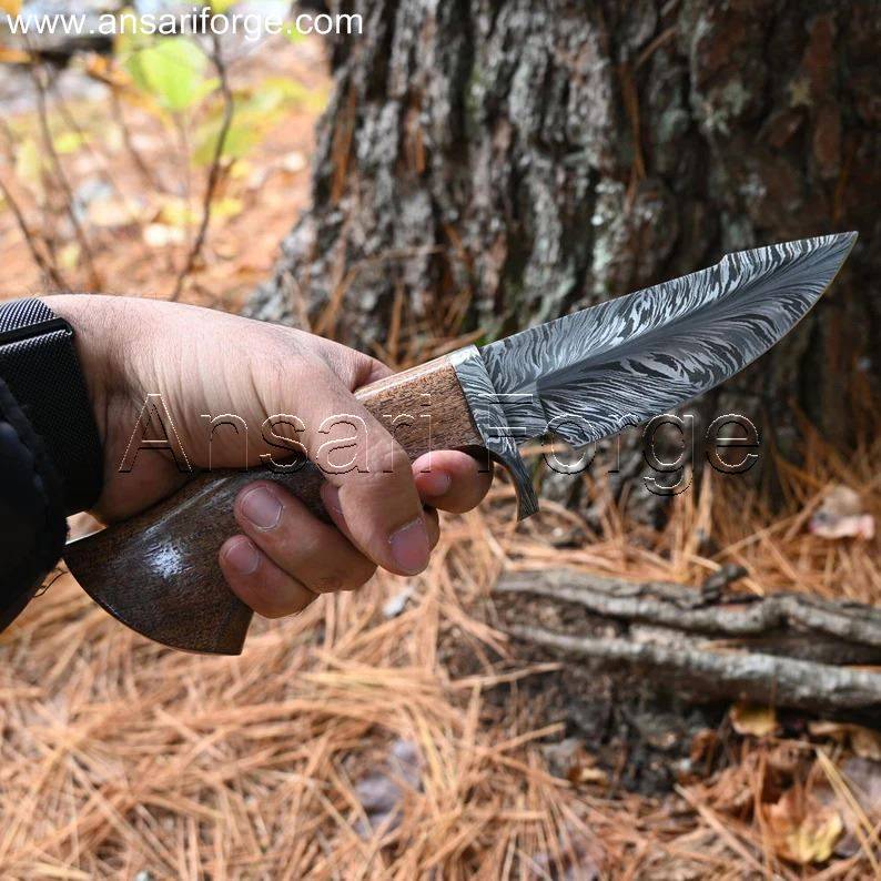 A hunter holding Feather Damascus Knife ready for skinning of a buck