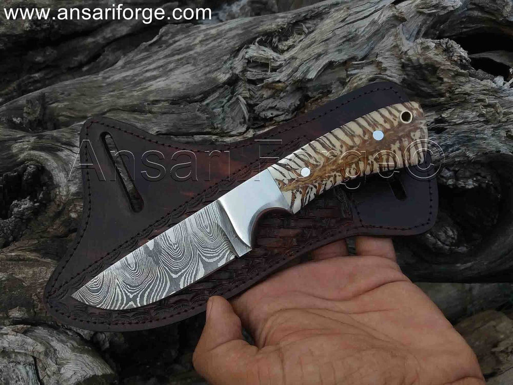 A person holding the Range Rider cowboy knife, showcasing its Damascus blade, handle, pancake sheath, size and design.