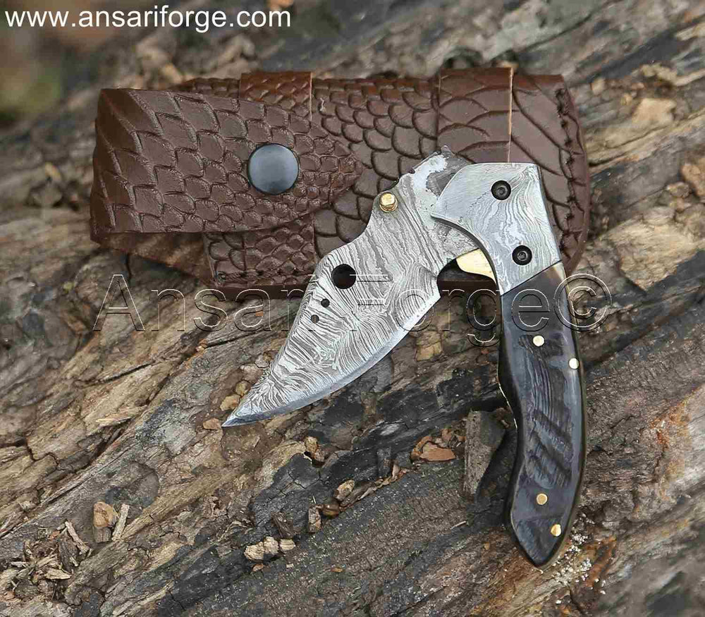 Damascus Pocket Knife by Ansari Forge with a 1095 & 15n20 Damascus steel blade, Himalayan sheep horn handle, and brass frame. Featuring a fire pattern, liner lock mechanism, and leather sheath.