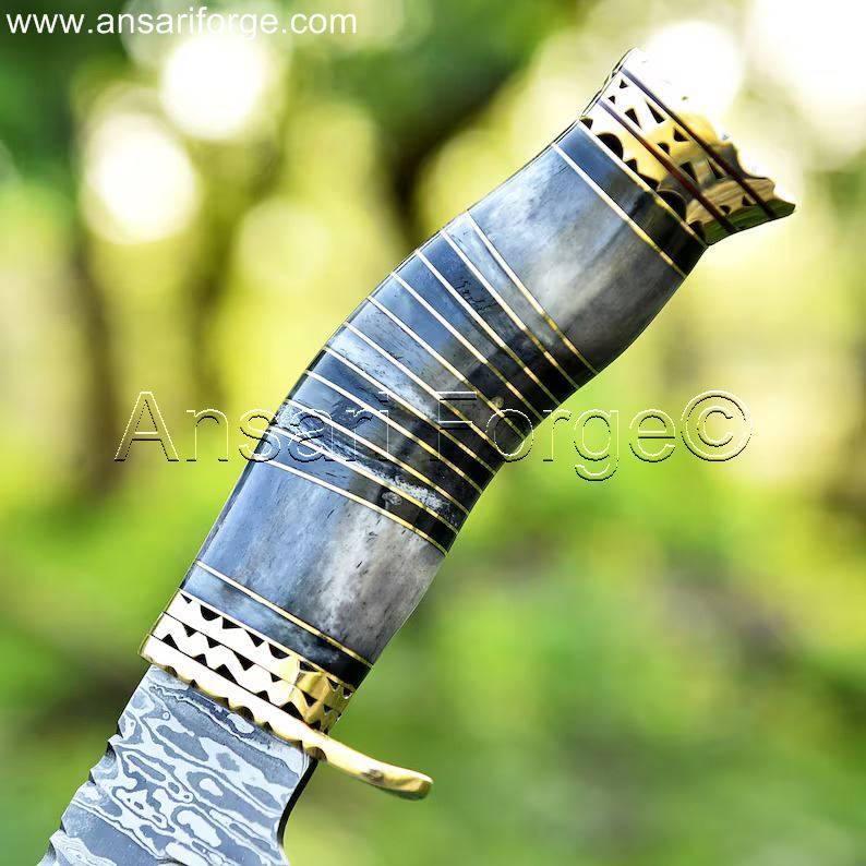Bone handle of a Damascus Bowie Hunting Knife with detailed carvings.