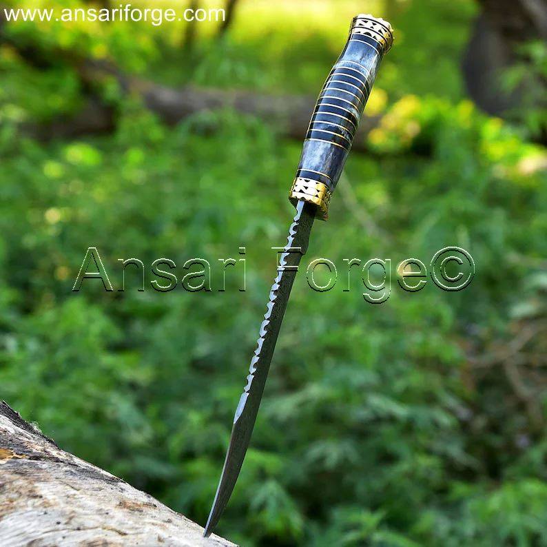 Close-up of a Damascus steel Bowie knife blade with a razor-sharp clip point.