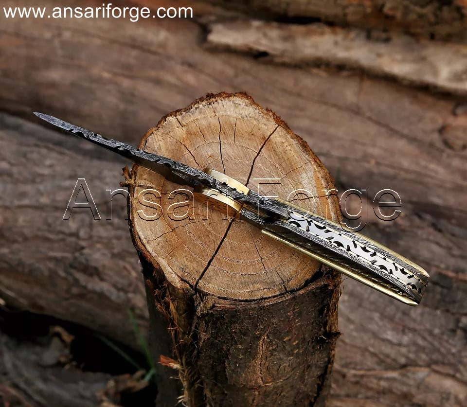Custom Damascus pocket knife with hand-forged blade and handle.