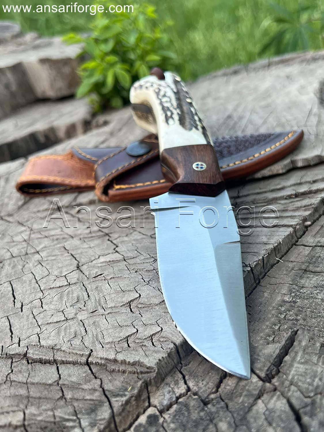 Handcrafted high carbon steel fixed blade hunting knife with stag/deer antler handle and rosewood bolsters, displayed in a cowhide leather sheath.