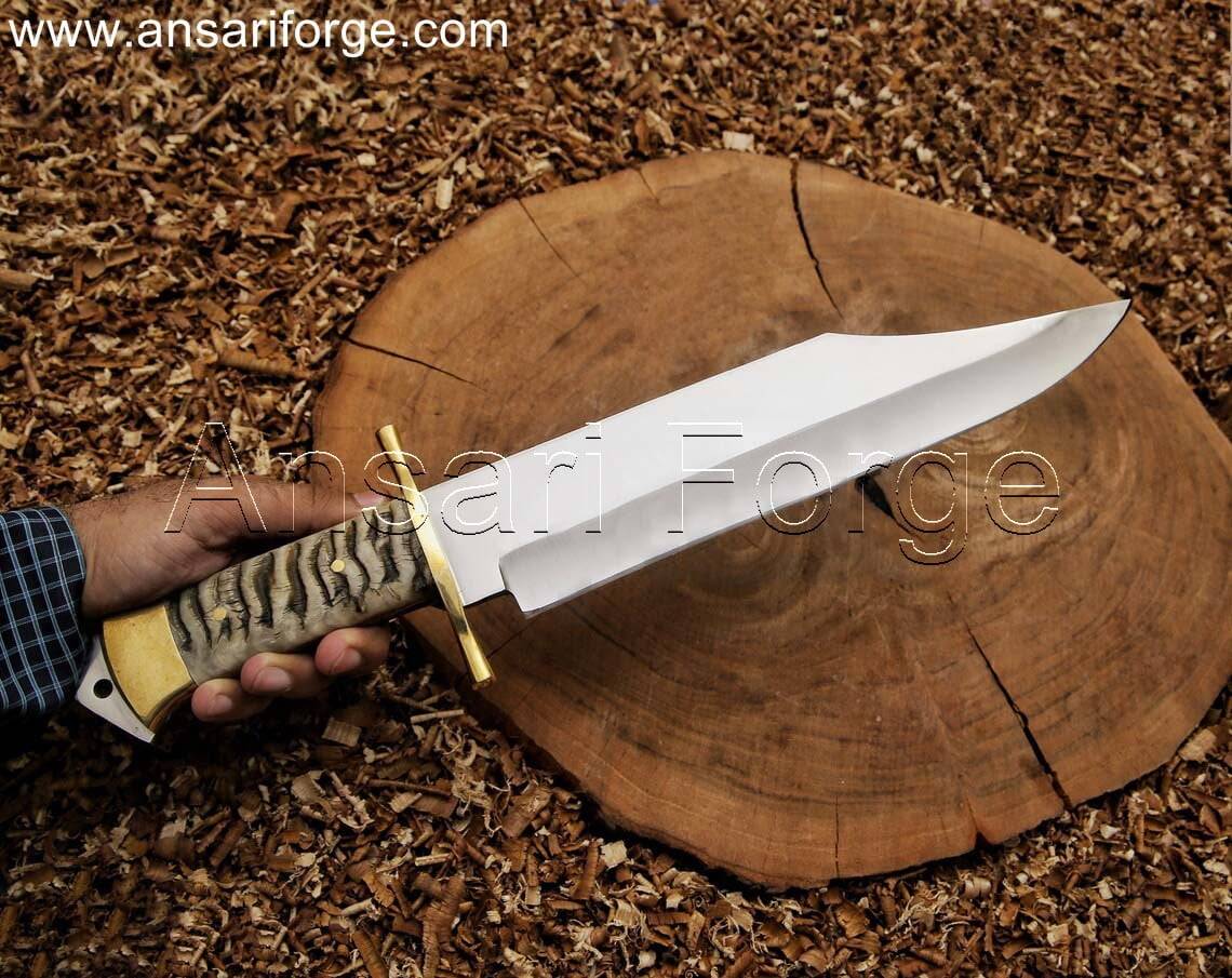 Custom handmade Bowie knife with 5160 steel clip point blade, ram horn handle, and leather sheath.