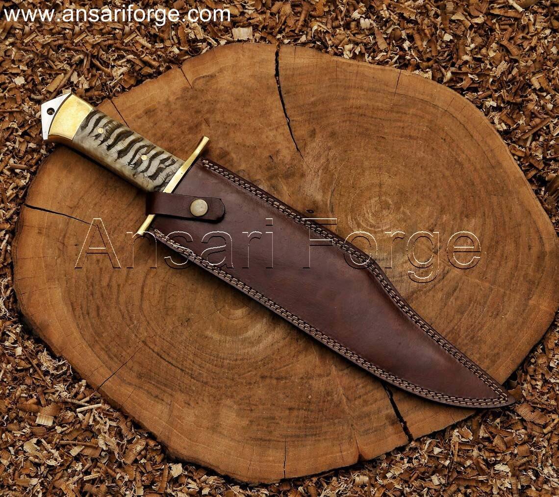 Custom handmade Bowie knife with 5160 steel clip point blade, ram horn handle, and leather sheath.