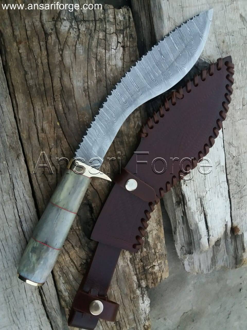 Close-up view of a beautiful Damascus kukri knife with a camel bone handle, leather sheath, and distinct layered blade pattern.