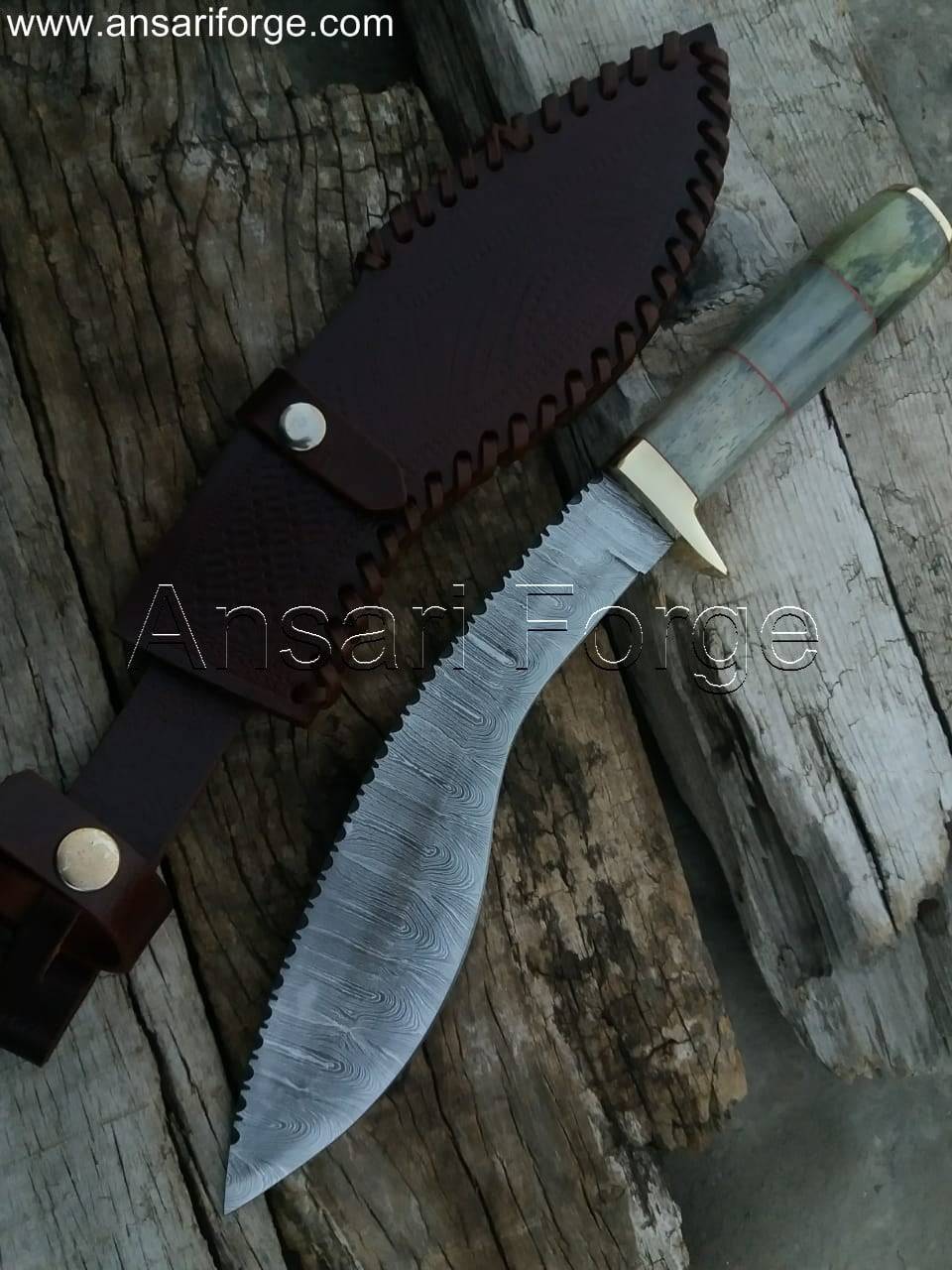 Close-up view of a beautiful Damascus kukri knife with a camel bone handle, leather sheath, and distinct layered blade pattern.