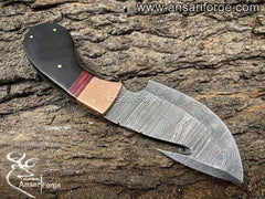 Hand forged Damascus steel gut hook skinning knife, showcasing intricate twist pattern and sharp blade.