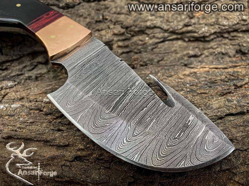 Detailed view of the Damascus steel blade of the skinning knife, showcasing the unique 526-layer twist pattern.