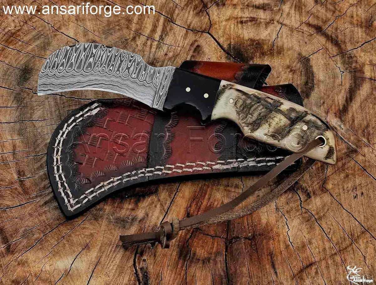 Hand-forged Hawkbill knife with Damascus steel blade, leather sheath and sheep horn handle.