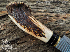 Deer antler handle of handmade Damascus hunting knife.
