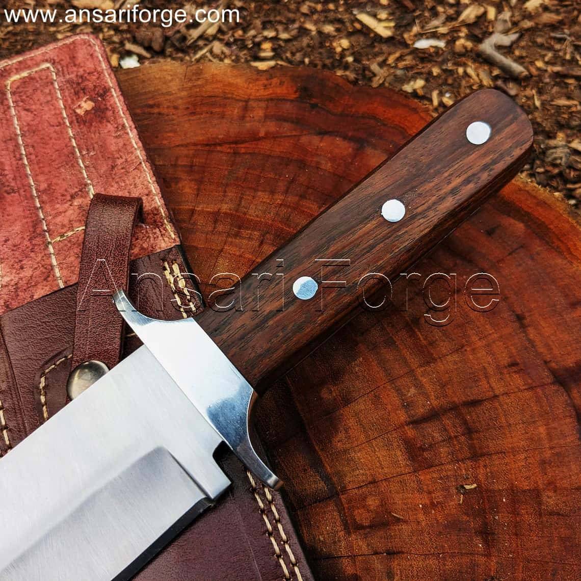 Red Dead Redemption 2 Bowie Knife handle, showcasing the rich rosewood grain and stainless steel guard.