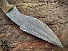 Close-up of a Damascus steel Bowie knife blade with a rain drop pattern.