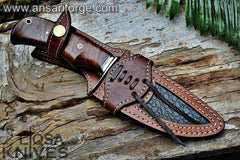 Custom handmade Damascus hunting knife resting in brown leather sheath.