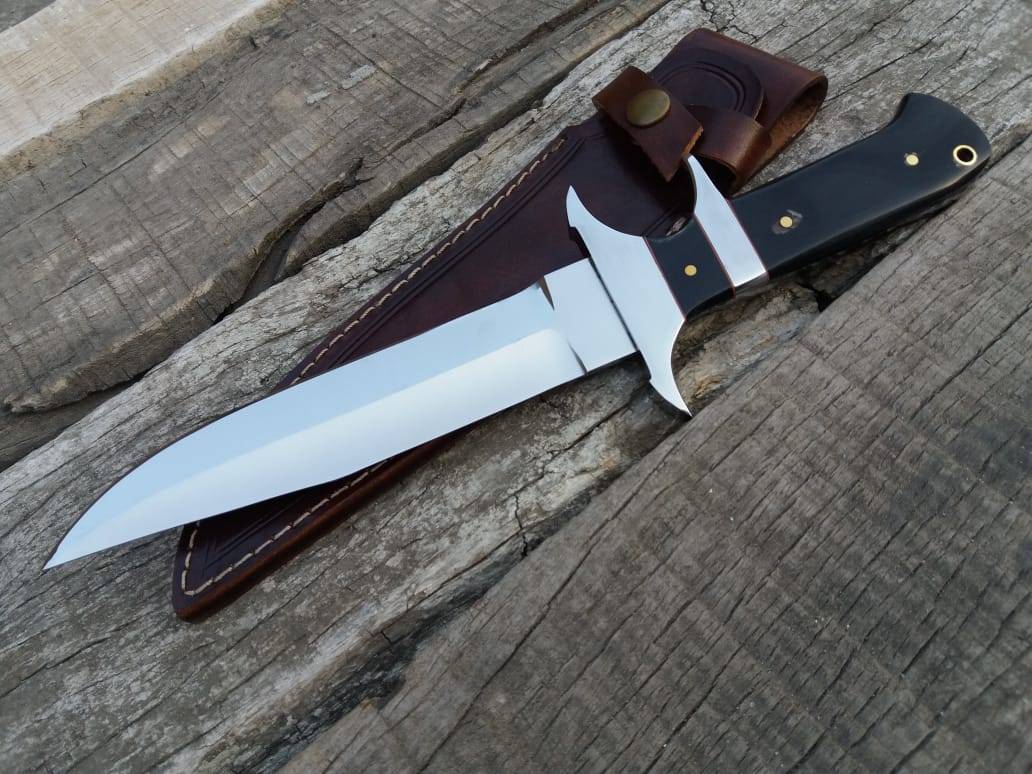 A rugged Loveless Knife, perfect for camping or survival situations. The sharp blade gleams in the sunlight, and the comfortable buffalo horn handle promises a secure grip.